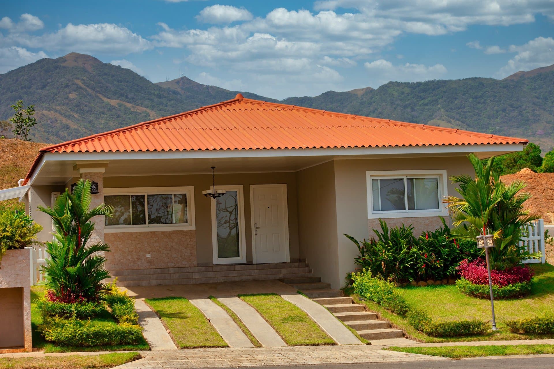 Villa modelo de Villas del María con techo de teja y las montañas de Chame al fondo